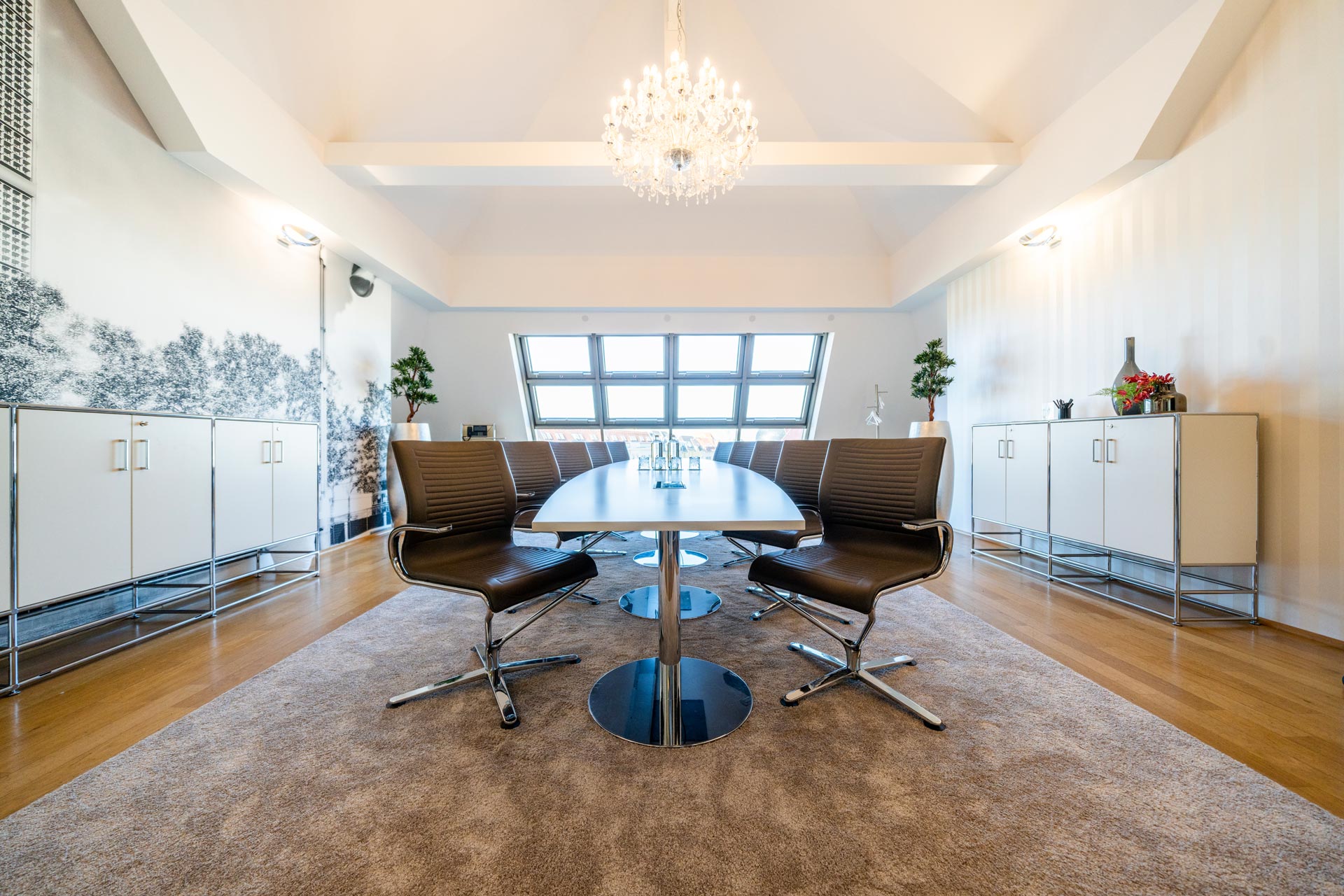 Helles modernes Besprechungszimmer mit elegantem Kronleuchter und stilvollen Stühlen