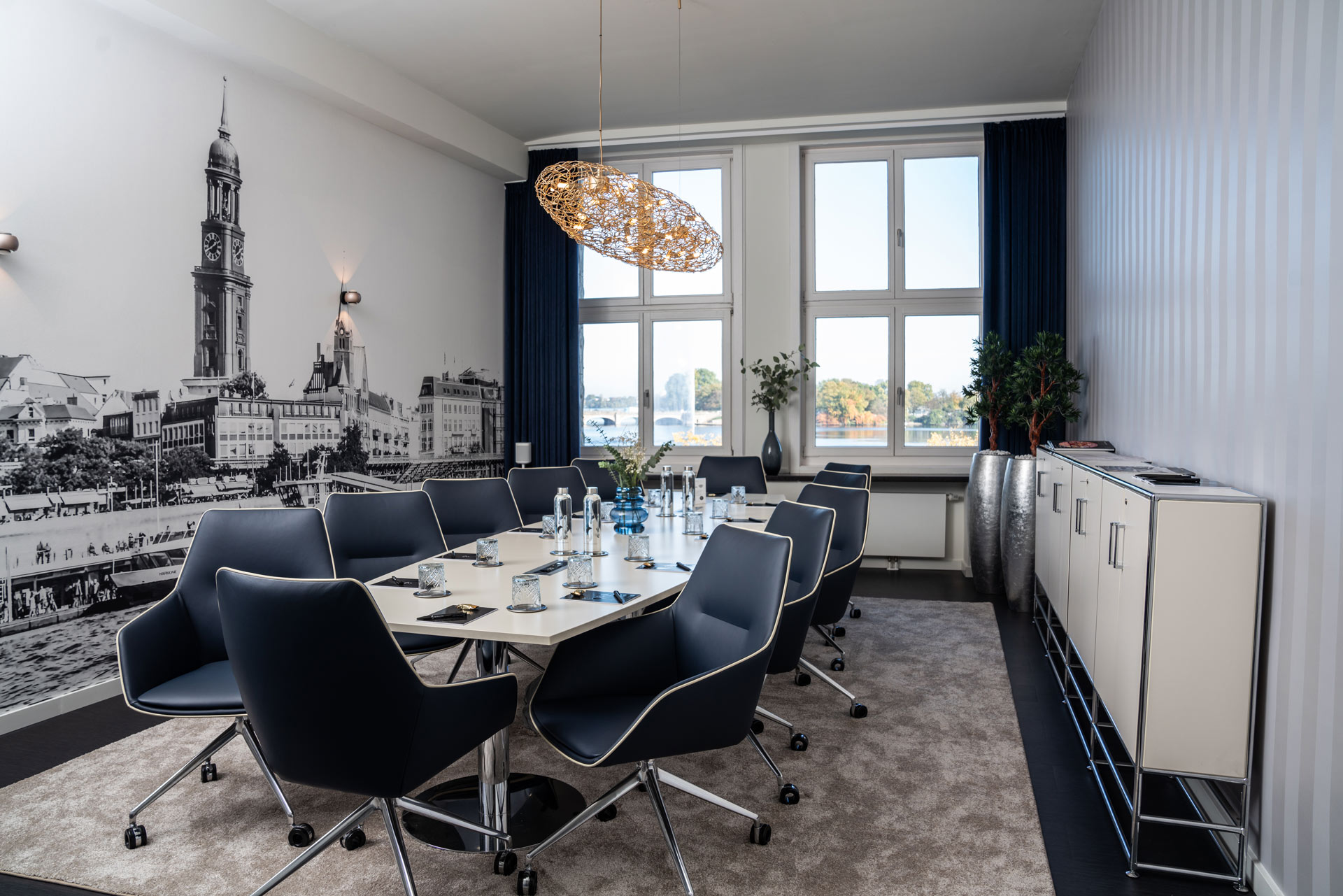 Moderner Konferenzraum mit großem Wandbild und elegantem Tisch im Sonnenlicht