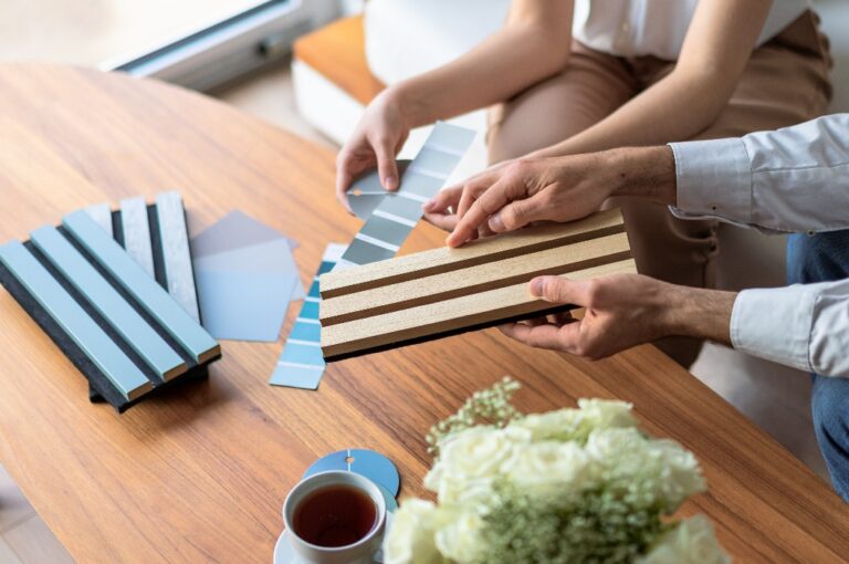 Ein Innenarchitekt und ein Kunde wählen Materialien für die Wohnraumgestaltung anhand von Mustern für Akustikplatten aus.