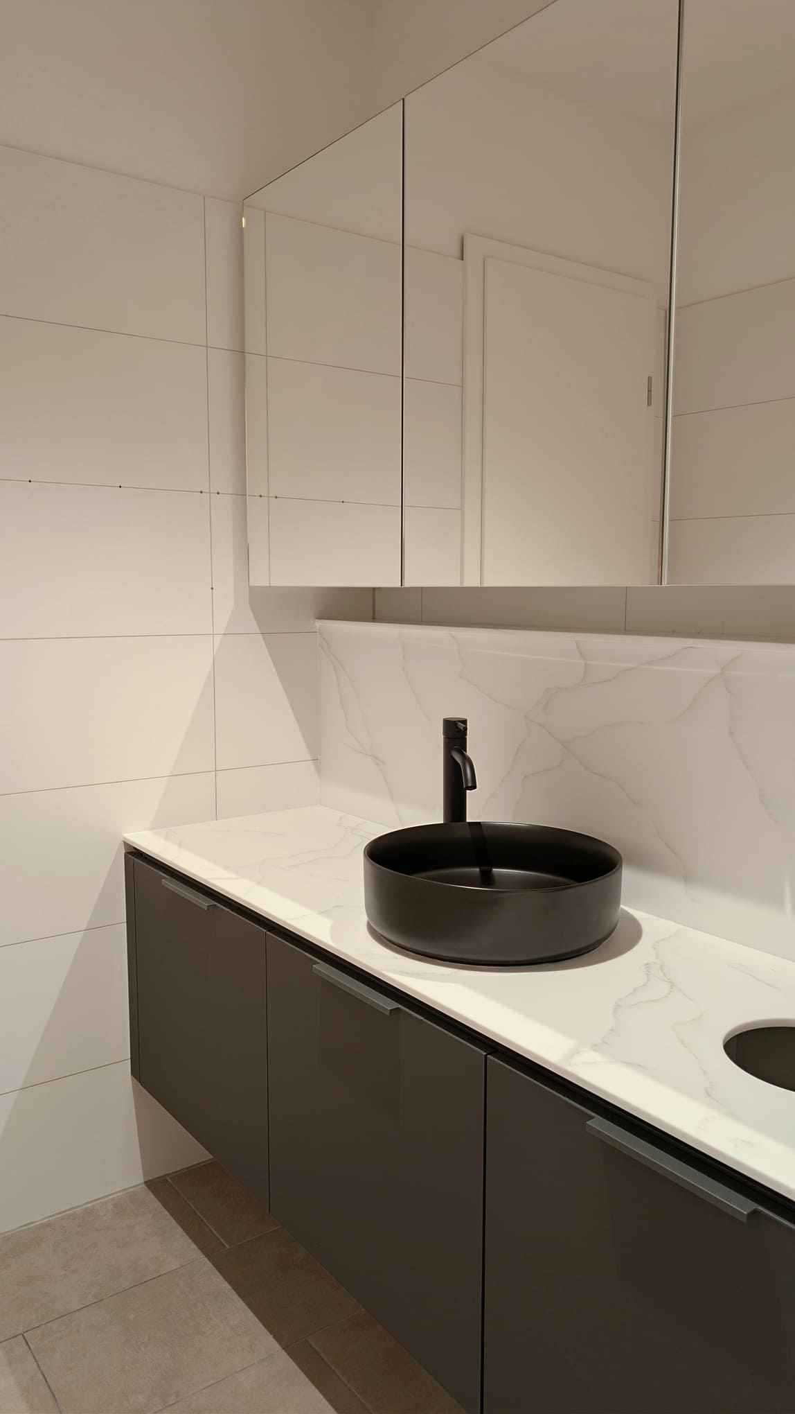Modernes Badezimmer mit schwarzem Aufsatzwaschbecken auf Marmorplatte